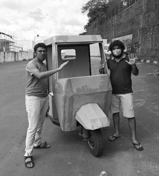 Black and white photo of the first L3 prototype with two people beside it