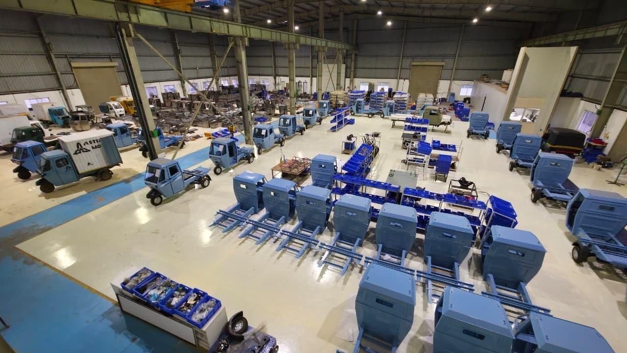Aerial view of the Astro Motors factory floor with rows of blue three-wheelers