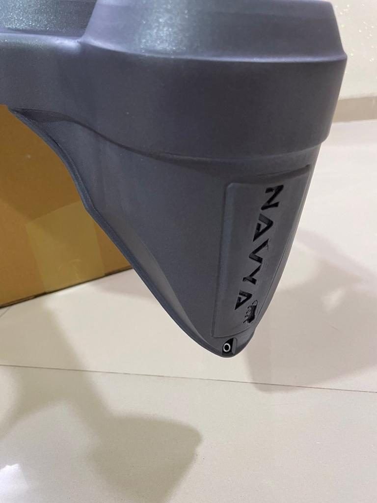 Close-up of the embossed Navya name on the headlight housing