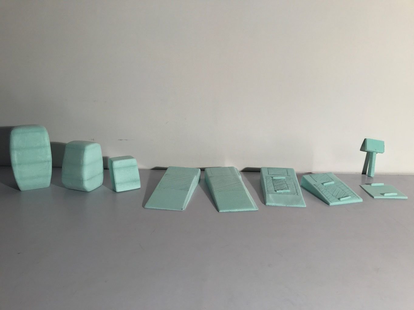 A row of green foam mock-ups on a desk